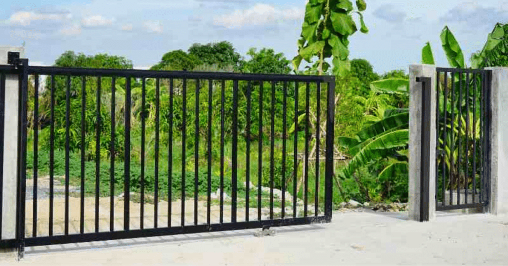 Black metal sliding gate with vertical bars.