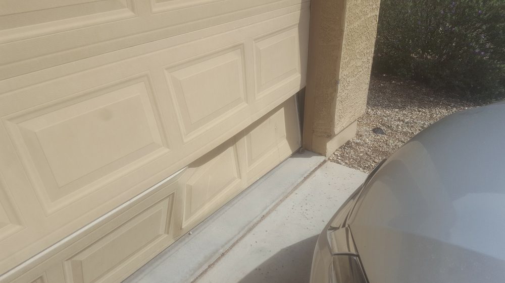 Garage door panel damage close-up before repair, Phoenix AZ