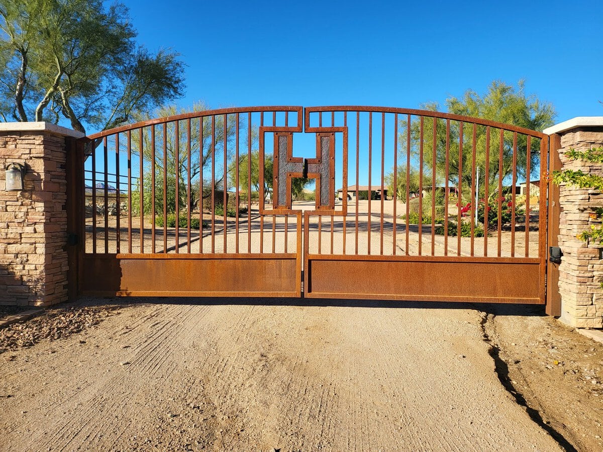 Corten steel arched driveway gate with custom H monogram, Scottsdale AZ