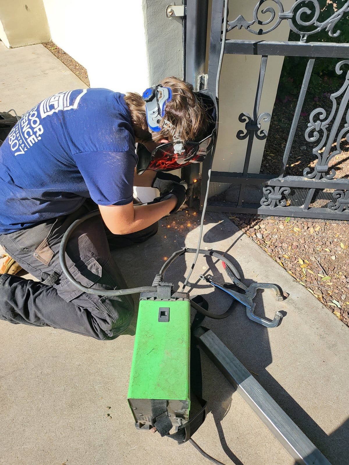 Technician welding ornate iron gate repair, Scottsdale AZ