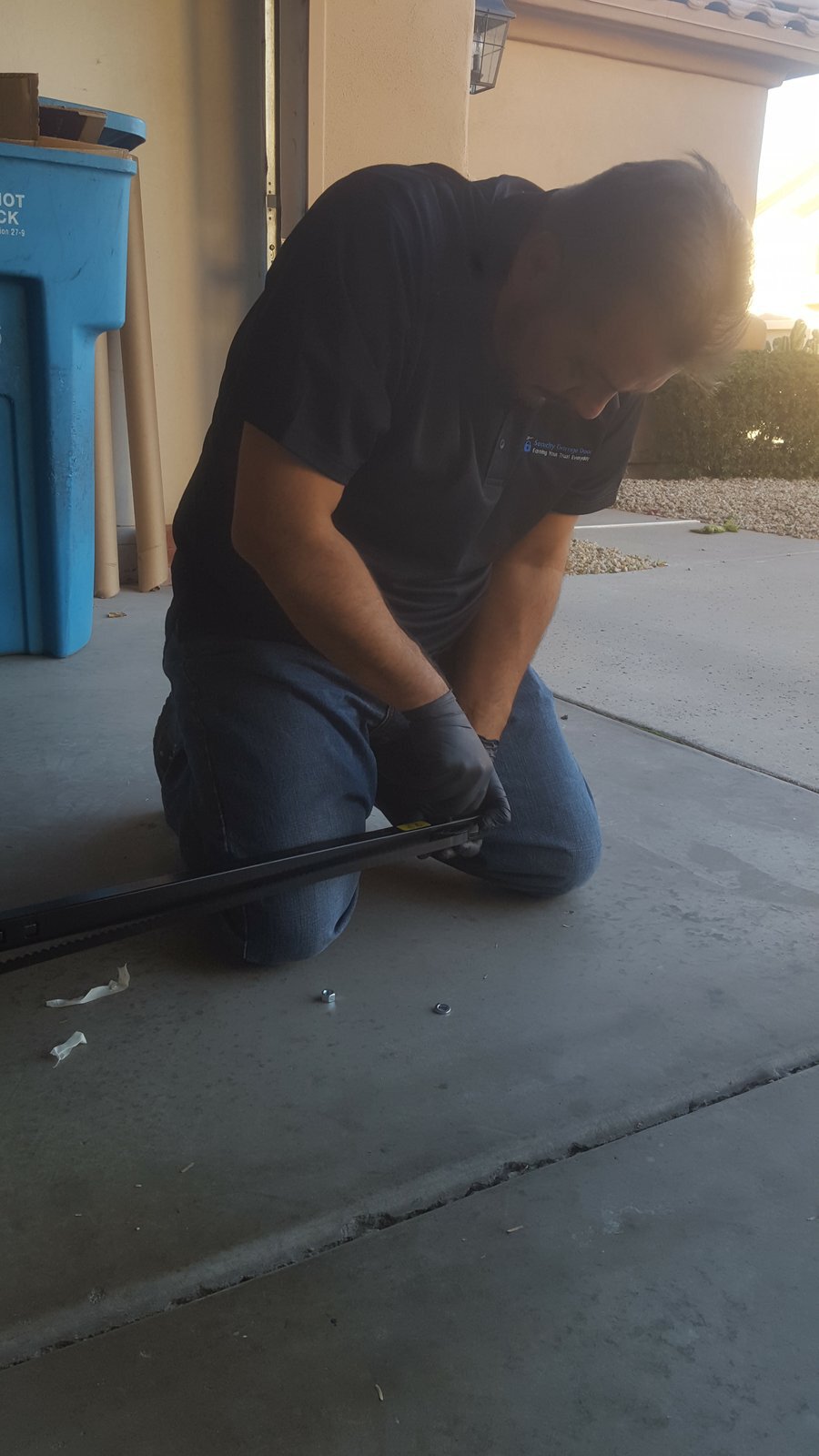 Technician repairing garage door opener track and rail, Scottsdale AZ