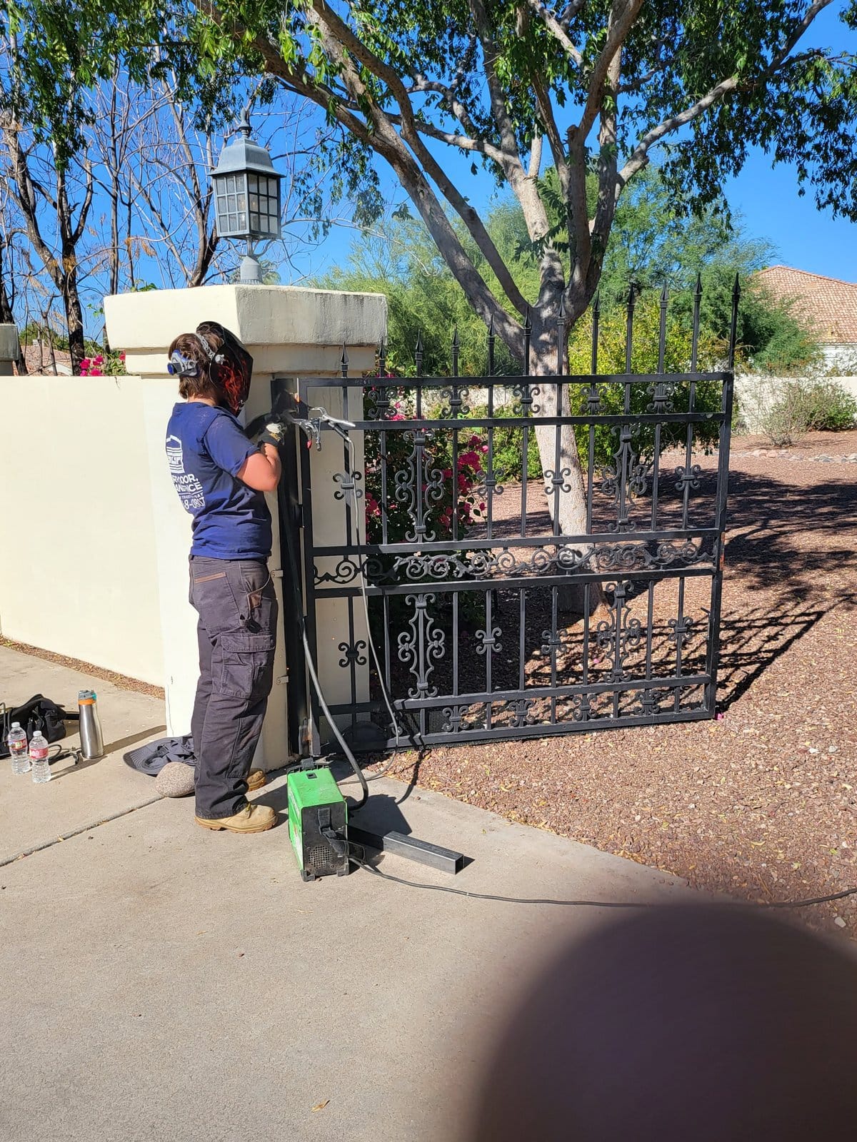 Technician welding gate hinge repair, Scottsdale AZ