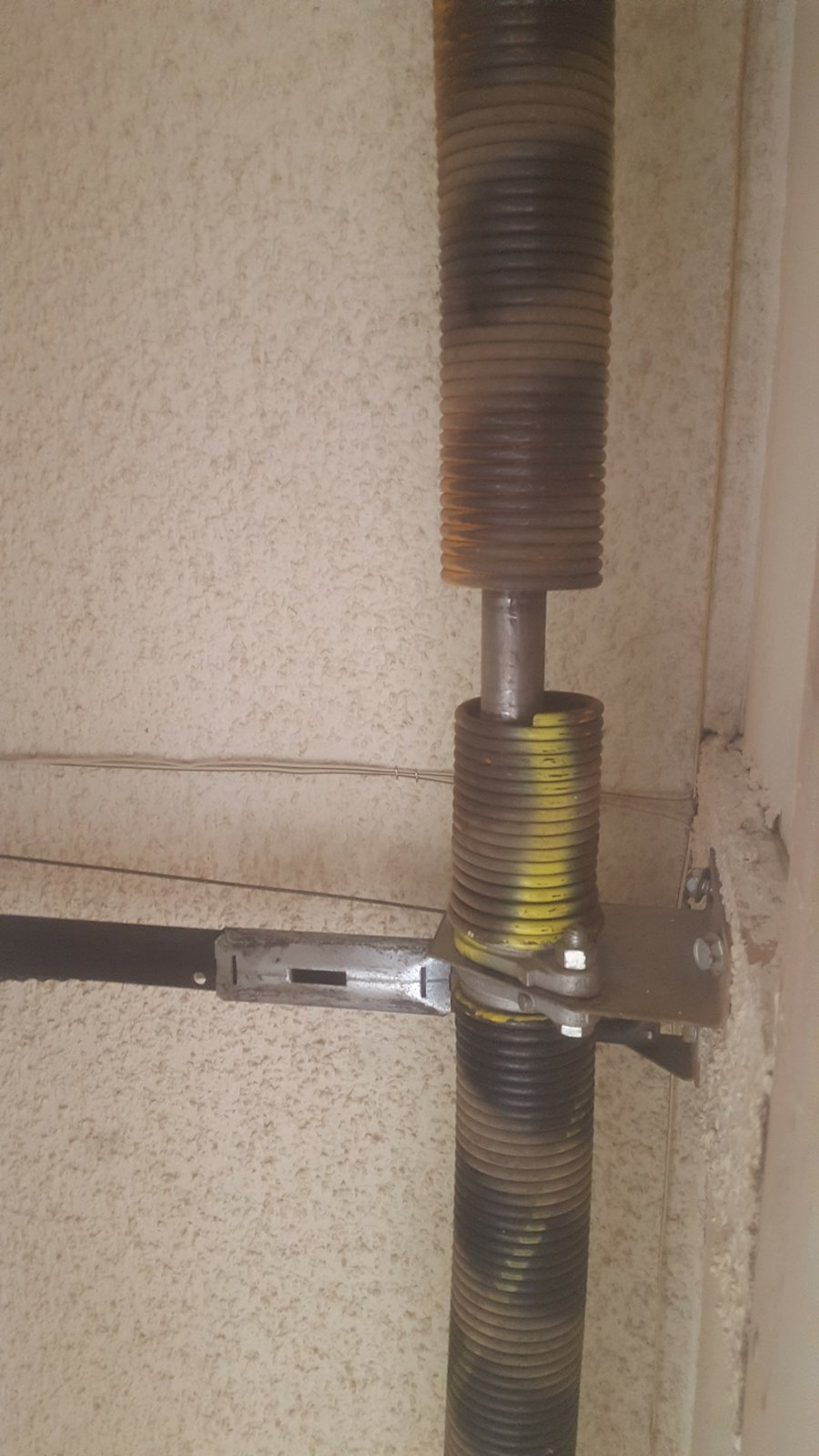 Close-up of broken garage door torsion springs before repair, Ahwatukee AZ