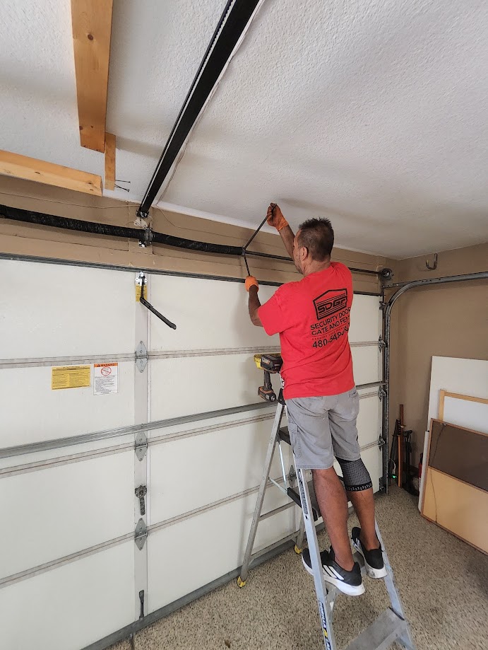 Security Door Gate and Fence technician winding garage door torsion spring in Phoenix AZ